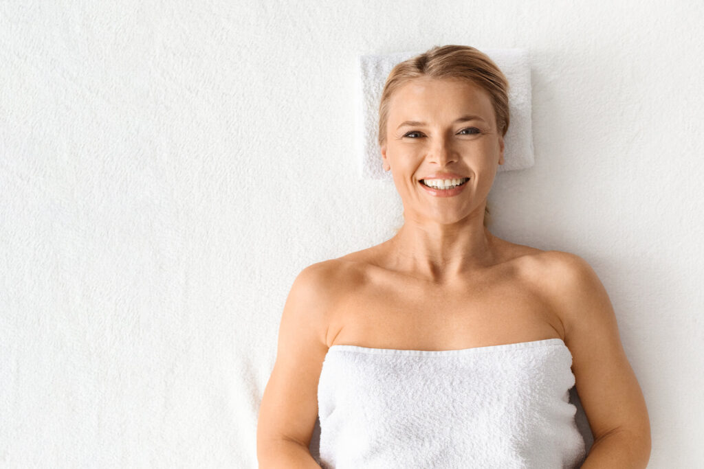 Smiling client with fresh, glowing skin after facial treatment at Lalwa Aesthetics, relaxing in a clean spa setting