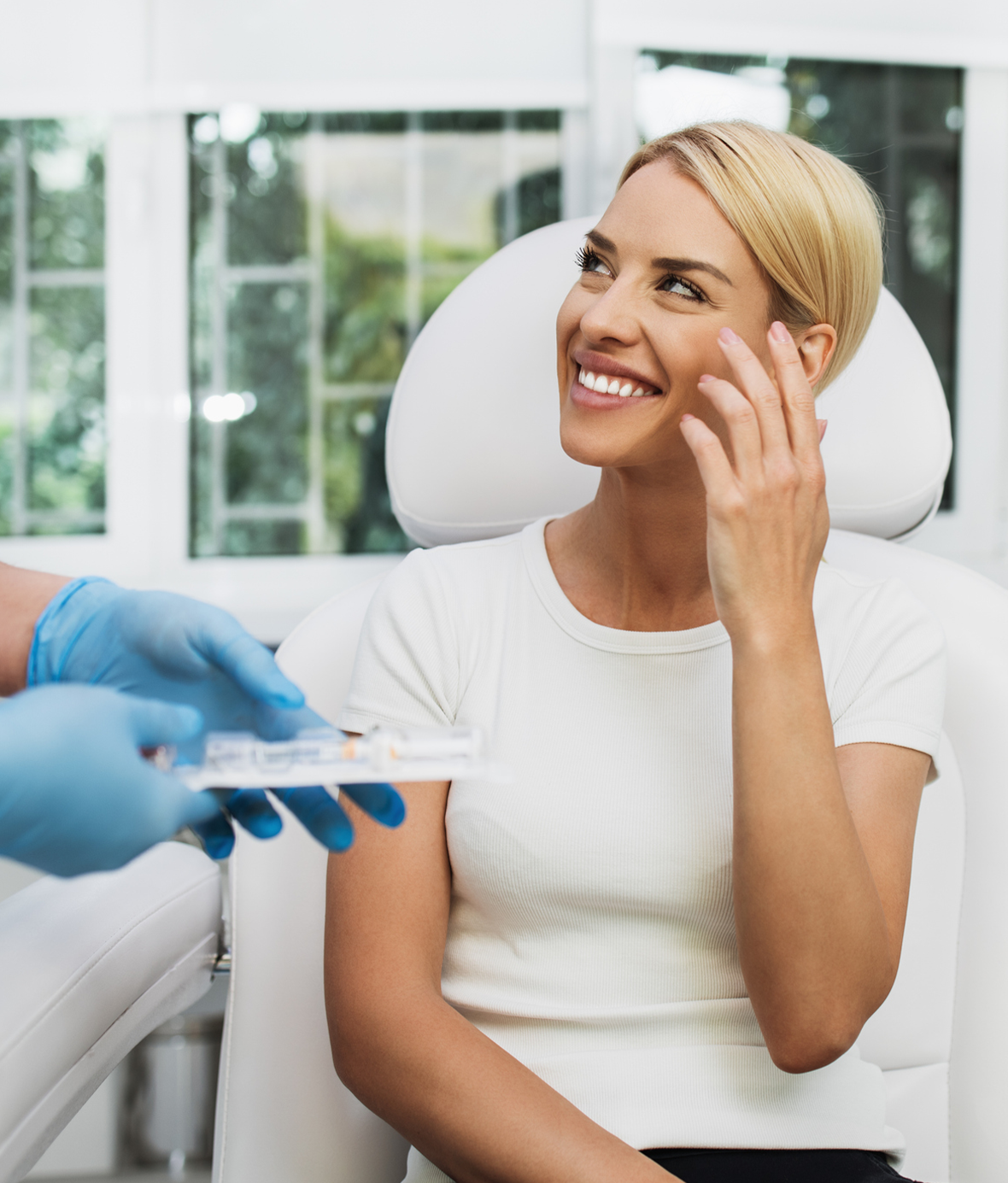 Smiling woman in clinic consultation receiving skincare or treatment advice from a professional in a medical setting
